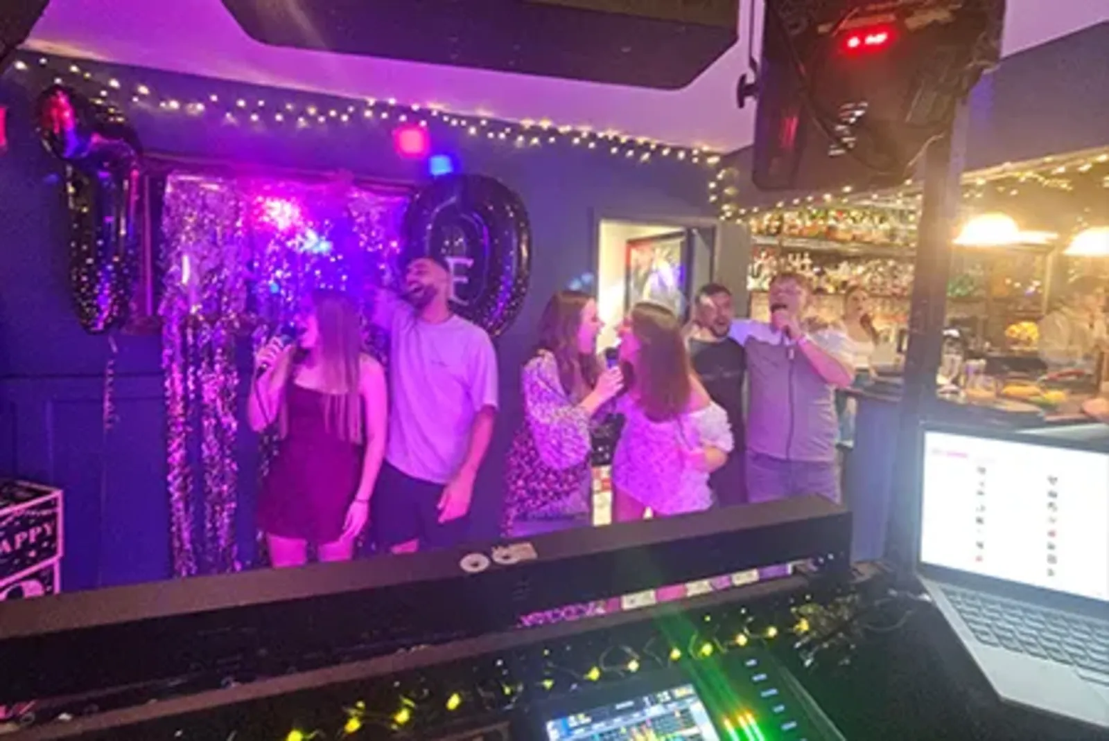 Friends sharing a microphone singing karaoke together