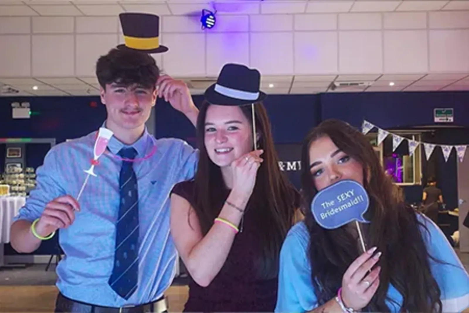 Guests posing with fun props in an Xtramagic photobooth